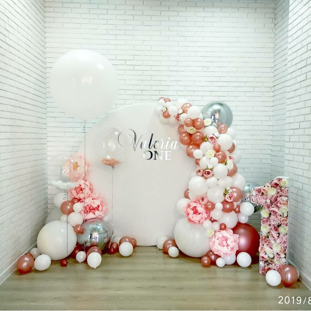круглая фотозона с гирляндой из белых и розовых шаров и цветочным декором