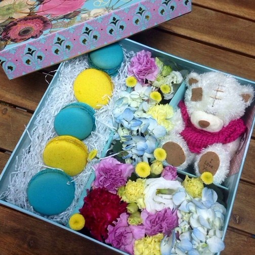 яркая подарочная коробка с цветами, макаруни и мягкой игрушкой