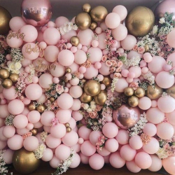 Фотозона-стена из розовых и золотых шаров с цветами